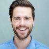 Portrait of a handsome young man with beard smiling